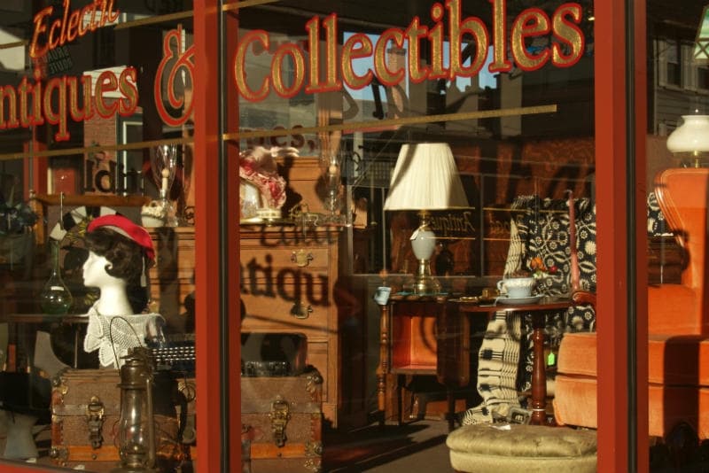 A window display of an antique shop showcasing various vintage items and collectibles.
