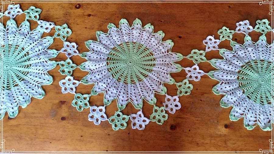 Crocheted cup mats lined up next to each other.