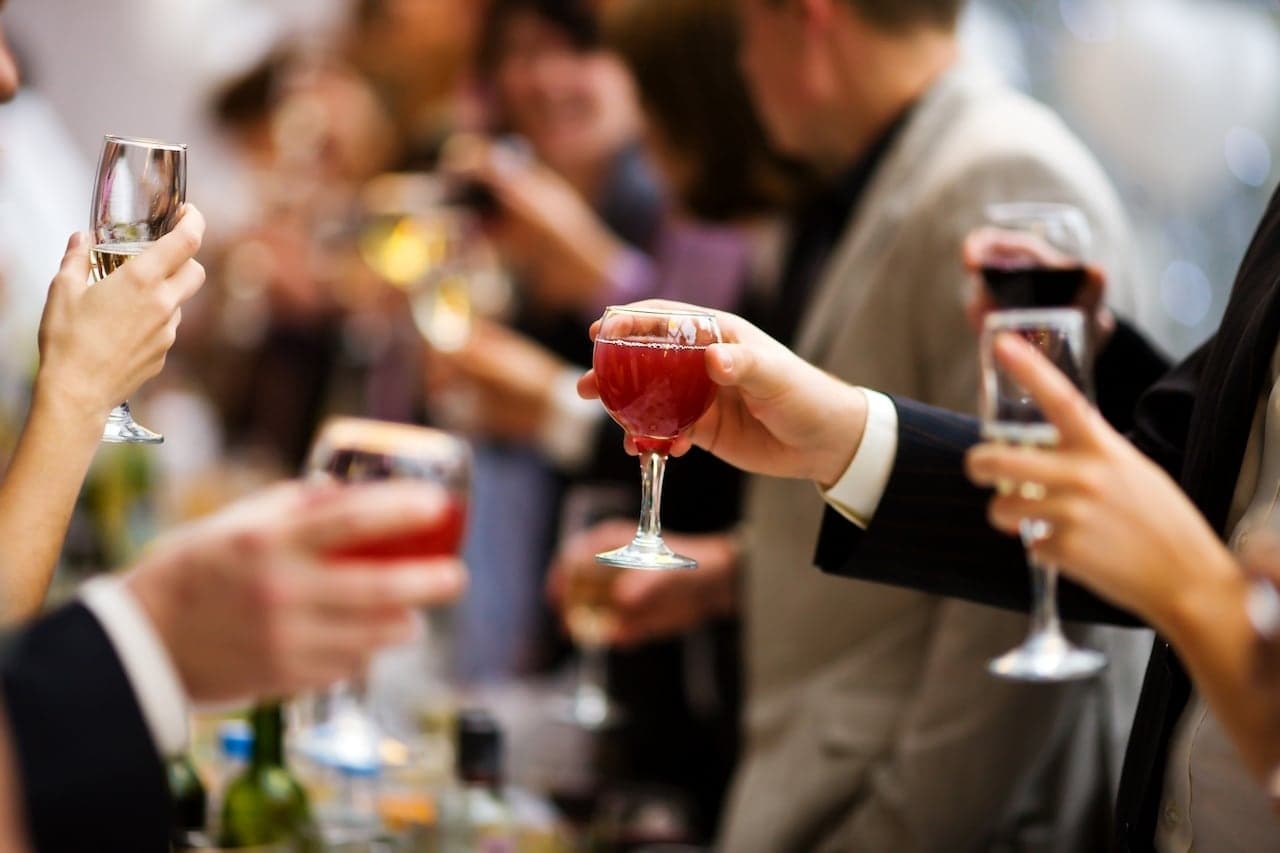 A group of people clink glasses filled with various drinks at a celebration.