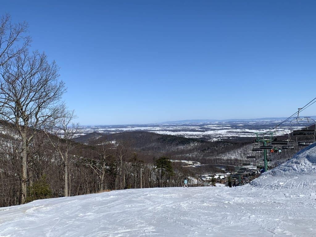 A snowy landscape with a ski lift and a clear blue sky.