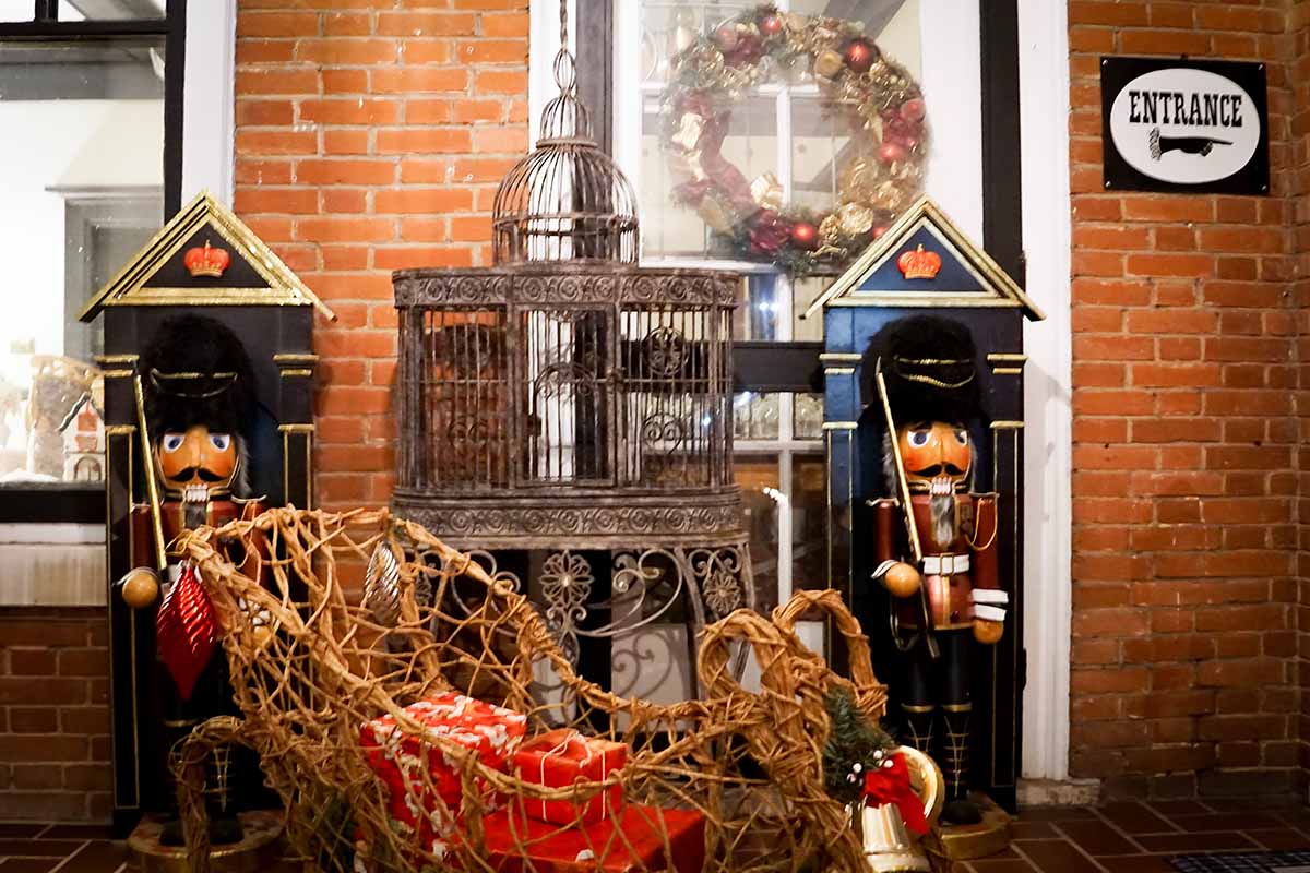 A festive entrance decorated with nutcracker figures, a birdcage, and a Christmas wreath.