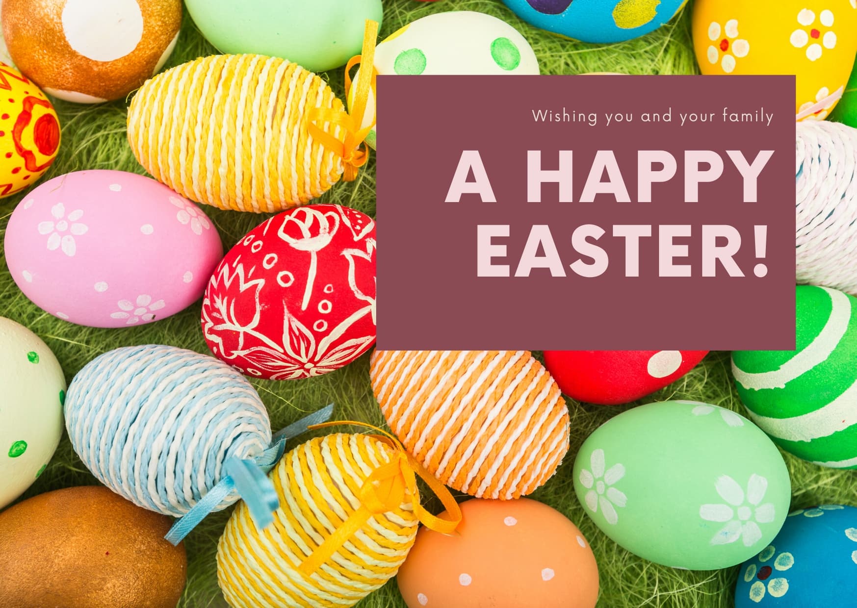 Colorful Easter eggs arranged on grass with a cheerful greeting.